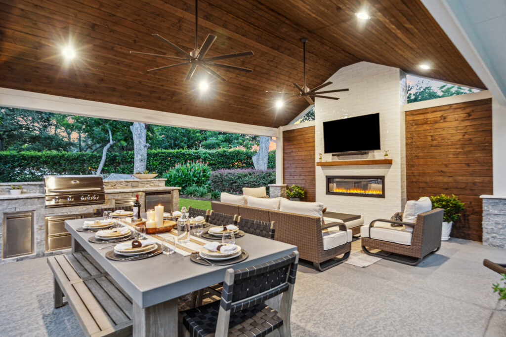 Under the patio cover with a view of the kitchen, the fireplace, the dining table and sitting area. 